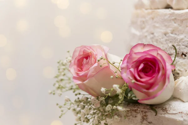 Primer plano de hermoso pastel de nivel de árbol blanco con flores frescas con bastante luz y linternas que brillan en el fondo. Enfoque selectivo. Copiar espacio . — Foto de Stock