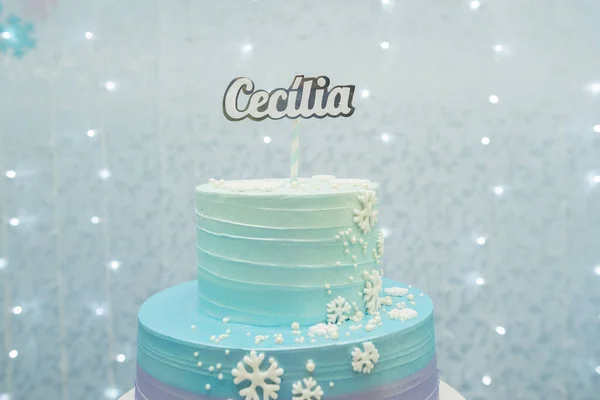Gesneden foto taart tonen details van prachtige blauwe en paarse verjaardag taart versierd met sneeuwvlokken. Twee lagen taart op blauwe achtergrond met niet-gerichte lichten. Studio foto met selectieve focus — Stockfoto