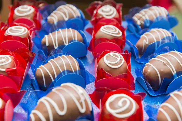 Närbild av läckra choklad godis. Olika typer av choklad godis på en blå och röd bakgrund - ovanifrån. — Stockfoto