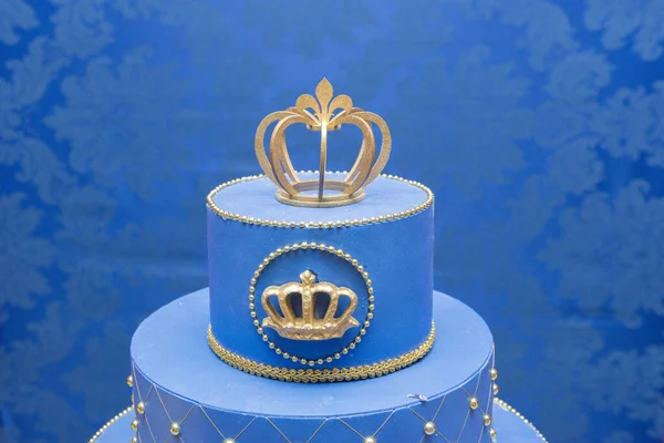 Fake blue birthday cake with a crown on top. Little prince or royal theme. Decorated table for child birthday celebration. Close up of decor party. — ストック写真