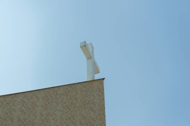 Mavi bir arka planda Katolik kilisesinde bir Hıristiyan haçı üzerinde uçan güvercin..