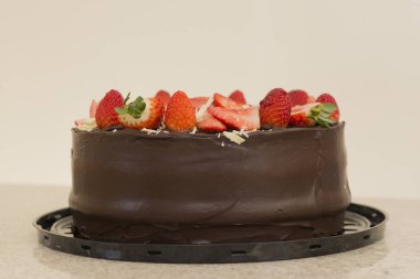 Bir sürü dilimlenmiş çilekle kaplı lezzetli çikolatalı pasta. Parti Konsepti. Seçici odak.