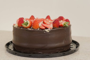 Bir sürü dilimlenmiş çilekle kaplı lezzetli çikolatalı pasta. Parti Konsepti. Seçici odak.