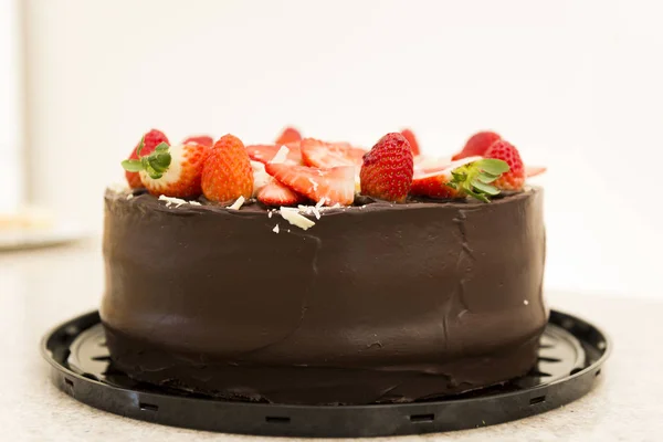 Delicious chocolate cake topped with many sliced strawberries. Party Concept. Selective focus. — Stock Photo, Image
