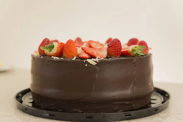 Heerlijke chocoladetaart belegd met veel gesneden aardbeien. Feestconcept. Selectieve focus. — Stockfoto
