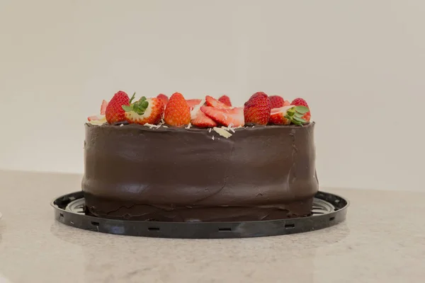 Pyszne ciasto czekoladowe zwieńczone wieloma plasterkami truskawek. Koncepcja partii. Skupienie selektywne. — Zdjęcie stockowe