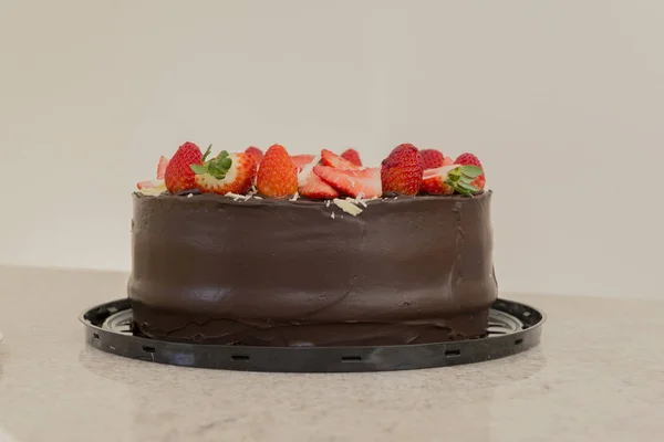 Delicious chocolate cake topped with many sliced strawberries. Party Concept. Selective focus. — Stock Photo, Image