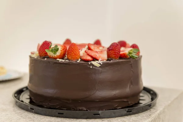 Delicious chocolate cake topped with many sliced strawberries. — Stock Photo, Image