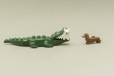 Lego minifigures - alligator biting a dog with its mouth full of teeth