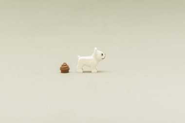 side view of a minifigure of a Lego white dog with his poop