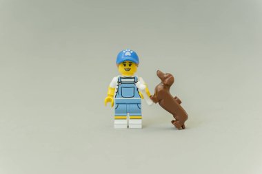 Standing tamer playing with her dog.
