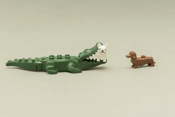 Lego minifigures - alligator biting a dog with its mouth full of teeth