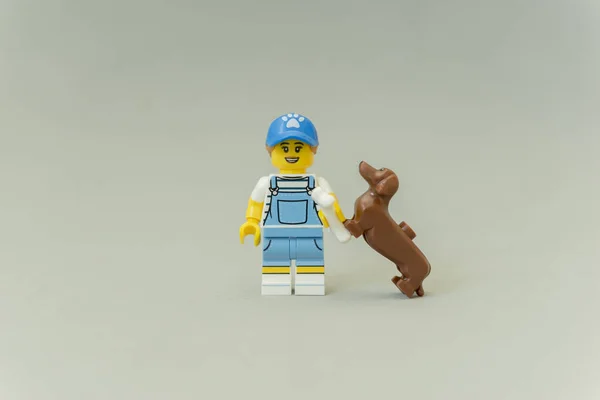 Standing tamer playing with her dog.