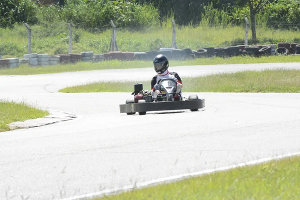 Front view of go-kart driver driving on race track on sunny day — 스톡 사진
