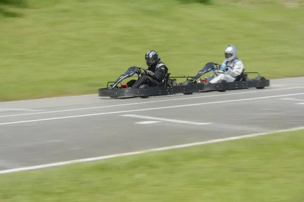 Seitenansicht des dynamischen Bildes zweier konkurrenzfähiger, sich schnell bewegender Go-Karts. — Stockfoto