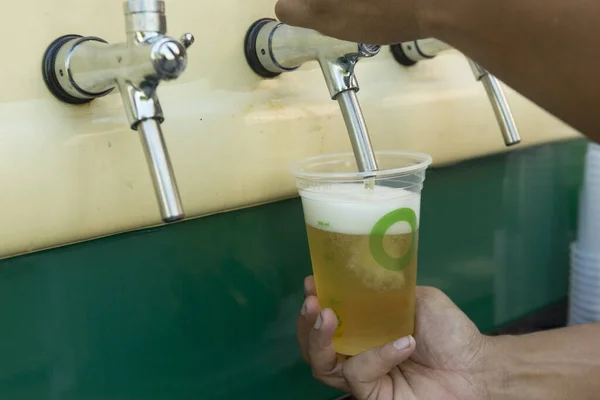 Barkeeper Gießt Aus Dem Fass Frisches Bier Den Plastikbecher Hände — Stockfoto