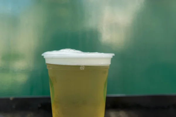 Großaufnahme Von Kaltem Bier Plastikglas Auf Grünem Hintergrund Goldenes Bier — Stockfoto
