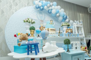 Mavimsi pastel renkli süslemeli bir çocuğun doğum günü partisi. Oyuncak ayılı, bulutlu, şekerli havacı temalı bir dekor. Zarif şeker masası ve güzel süslenmiş pasta..