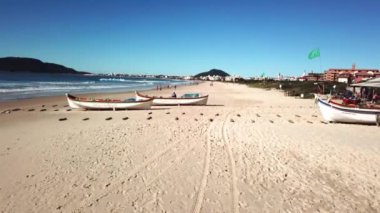 Florianopolis - Brezilya. 24 Mayıs 2020: kumlu sahilde uçarken, tahta kanolar ve balık sürüsü bekleyen balıkçılar. Kışın güzel tropikal plajlar.