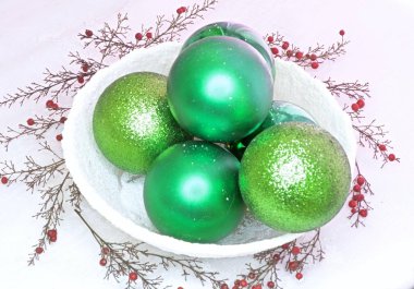 Karlı bir kasede yeşil toplar ve meyveler