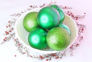 Karlı bir kasede yeşil toplar ve meyveler