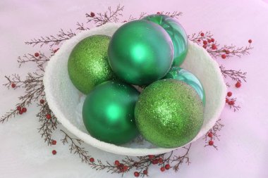 Karlı bir kasede yeşil toplar ve meyveler