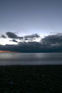 Gece çöl çakıl taşı plajı Alacakaranlık gökyüzüne bakıyor