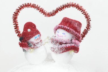 a pair of snowmen under the red outline of the heart