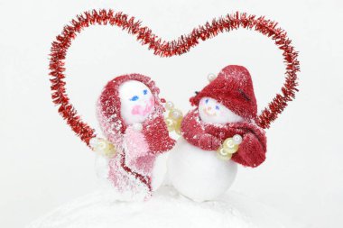 a pair of snowmen under the red outline of the heart