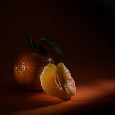 Portakal meyvesi ışık ve yaprak sapıyla izole edilmiş.