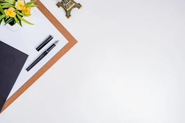 Ofis aksesuarları olan çalışma alanı ofis masaüstü. Defter, kalem, kahve ve çiçekli bir masa. Kopyalama alanı olan üst görünüm.