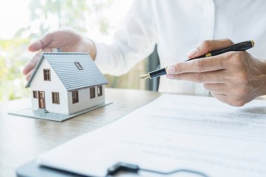 Temsilciyle ev modeli, müşteriden satın almak, sigorta yaptırmak ya da emlak veya mülk almak için kontrat istiyor.