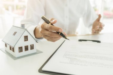 Emlakçı ve müşteri ev, sigorta ya da kredi sözleşmesi imzalıyor.