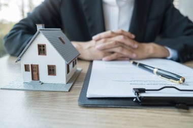 Temsilciyle ev modeli, müşteriden satın almak, sigorta yaptırmak ya da emlak veya mülk almak için kontrat istiyor.