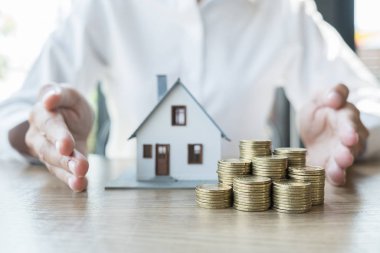 Sigorta konsepti. Ev sigortası için müşterilere ev sigortası yaptıran ajans el koruması modeli..