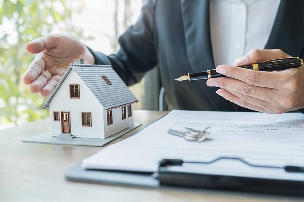 Hausmodell mit Makler, der den Kunden um einen Vertrag zum Kauf, zur Versicherung oder zum Darlehen von Immobilien oder Immobilien bittet. — Stockfoto