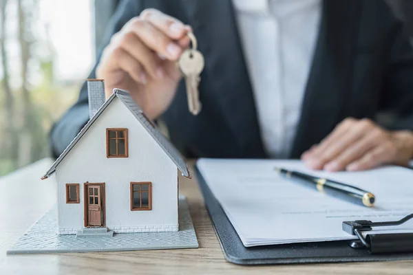 Modelo de casa con agente de bienes raíces y cliente discutiendo por contrato para comprar casa, seguro o préstamo fondo de bienes raíces . — Foto de Stock