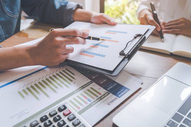 Ekonomik veriler ve rapor grafikleriyle beyin fırtınası yapıp tartışıyorlar. Takım çalışması çalışma konsepti.