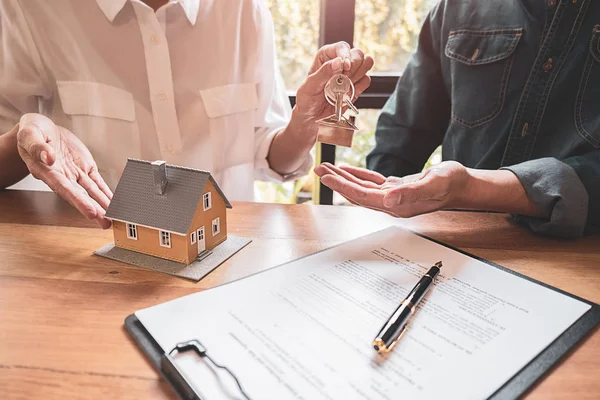 Hausmodell mit Makler und Kunde, die über einen Kaufvertrag, eine Versicherung oder ein Darlehen für Immobilien oder Immobilien diskutieren. — Stockfoto