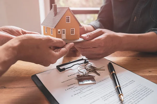 Modelo de casa con agente y cliente discutiendo por contrato para comprar, obtener seguro o préstamo de bienes raíces o propiedad. — Foto de Stock