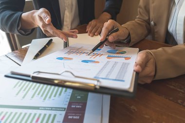 Ekonomik veriler ve rapor grafikleriyle beyin fırtınası yapıp tartışıyorlar. Takım çalışması çalışma konsepti.