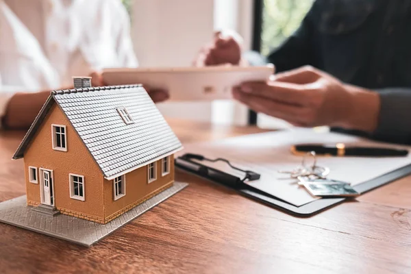 Hausmodell mit Makler und Kunde, die über einen Kaufvertrag, eine Versicherung oder ein Darlehen für Immobilien oder Immobilien diskutieren. — Stockfoto