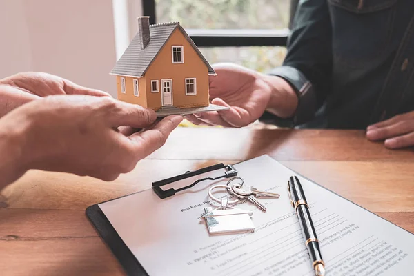 Model rumah dengan agen dan pelanggan yang mendiskusikan kontrak untuk membeli, mendapatkan asuransi atau pinjaman real estate atau properti. — Stok Foto