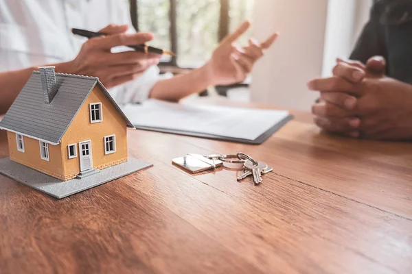 Hausmodell mit Makler und Kunde, die über einen Kaufvertrag, eine Versicherung oder ein Darlehen für Immobilien oder Immobilien diskutieren. — Stockfoto