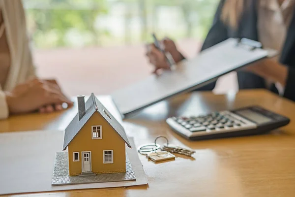 Ház modell ügynök és ügyfél megvitatása szerződés megvásárlására, kap biztosítási vagy kölcsön ingatlan vagy ingatlan. — Stock Fotó