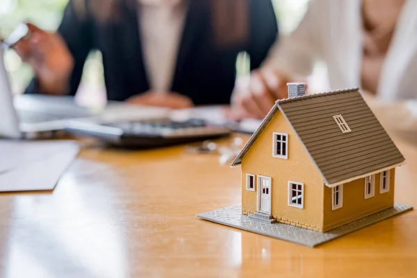 Modello di casa con agente e cliente discutere per il contratto di acquistare, ottenere l'assicurazione o prestito immobiliare o immobiliare. — Foto Stock