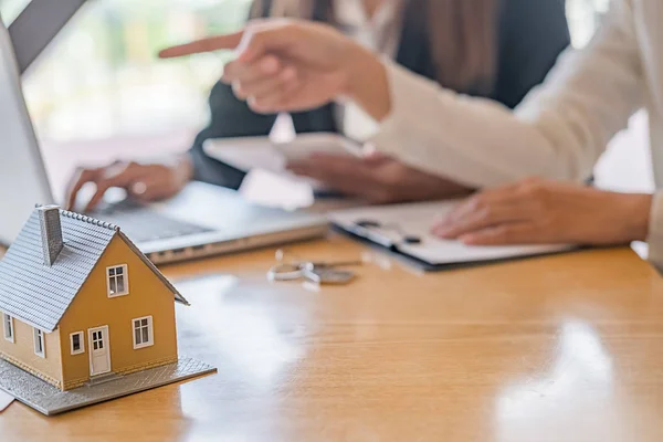 Hausmodell mit Makler und Kunde, die über einen Kaufvertrag, eine Versicherung oder ein Darlehen für Immobilien oder Immobilien diskutieren. — Stockfoto