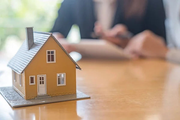 Modelo de casa con agente y cliente discutiendo por contrato para comprar, obtener seguro o préstamo de bienes raíces o propiedad. — Foto de Stock