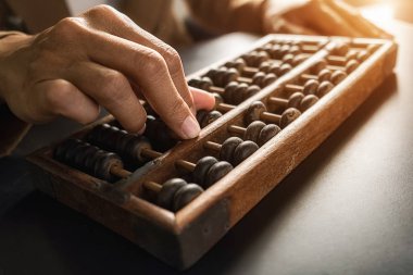 Asyalı kadın yaşlı abaküs ile muhasebe yapıyor. Finansal tasarım kavramı.