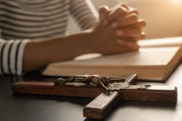 Mujer cristiana orando con las manos juntas en la santa Biblia y la cruz de madera. Mujer rezar para que Dios bendiga a desear tener una vida mejor y creer en la bondad. — Foto de Stock